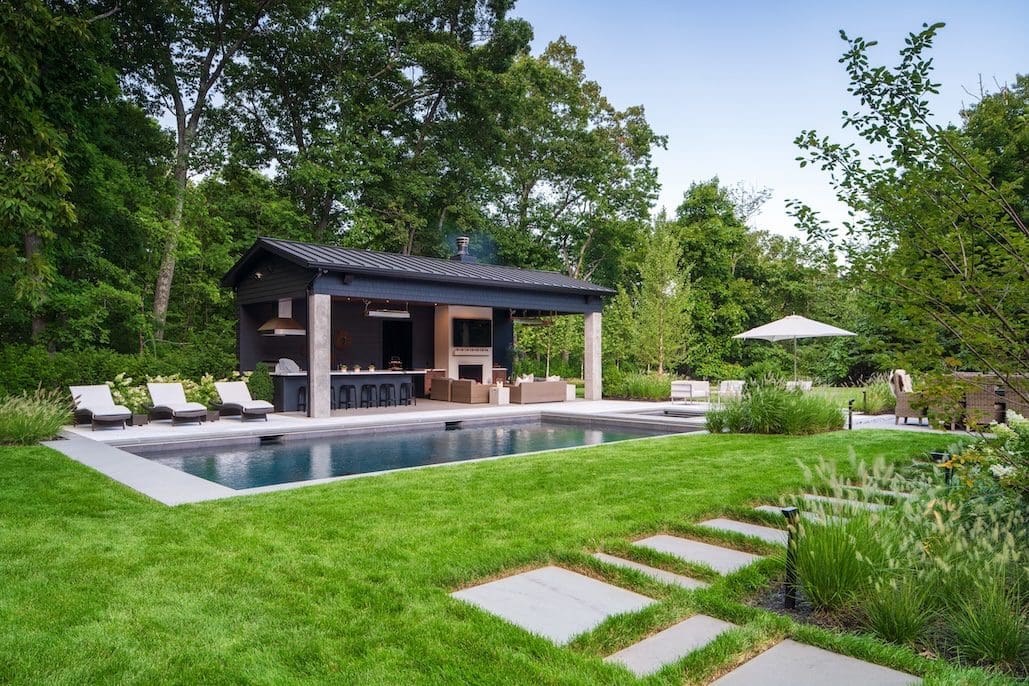 Nice green lawn by a stone walkway in Weston, MA from the lawn care service Lynch Landscape & Tree Service